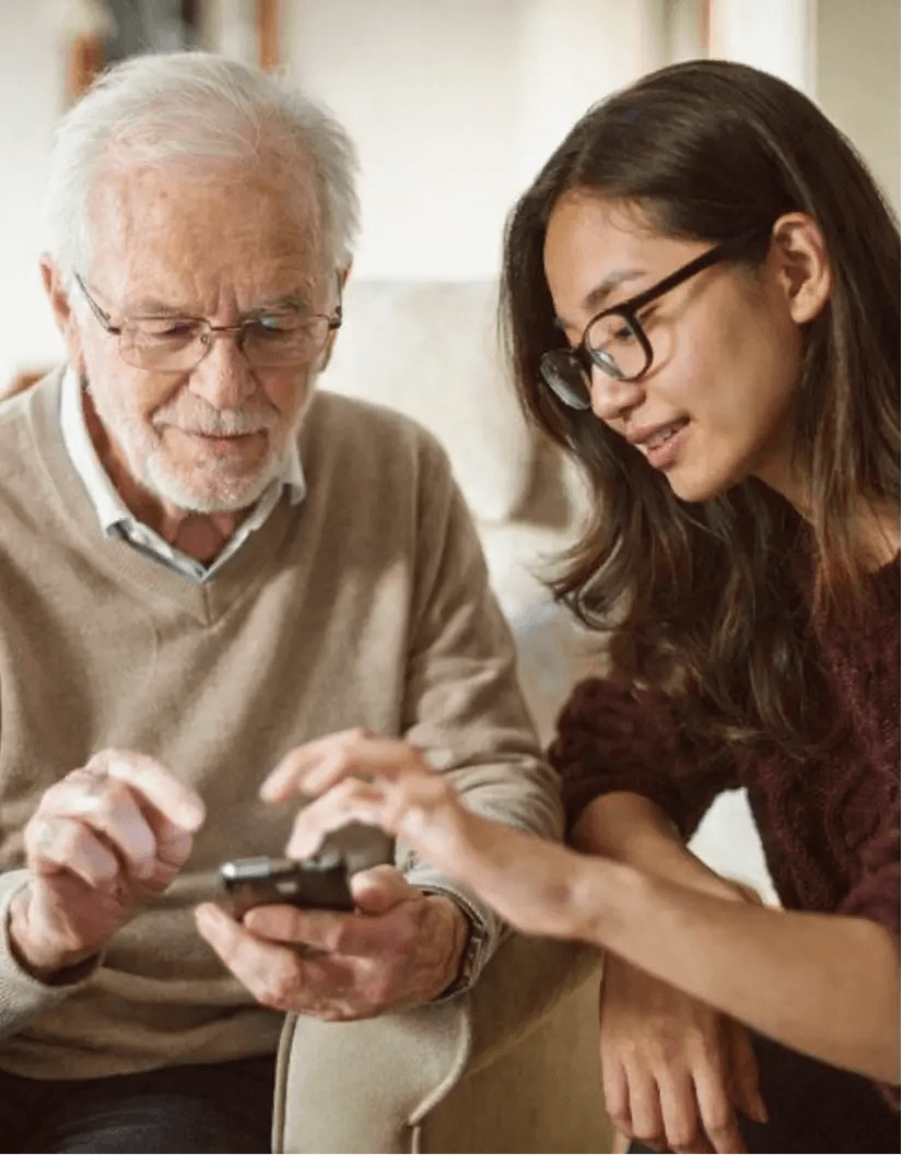 Student helpt een oudere met digitale apparaten